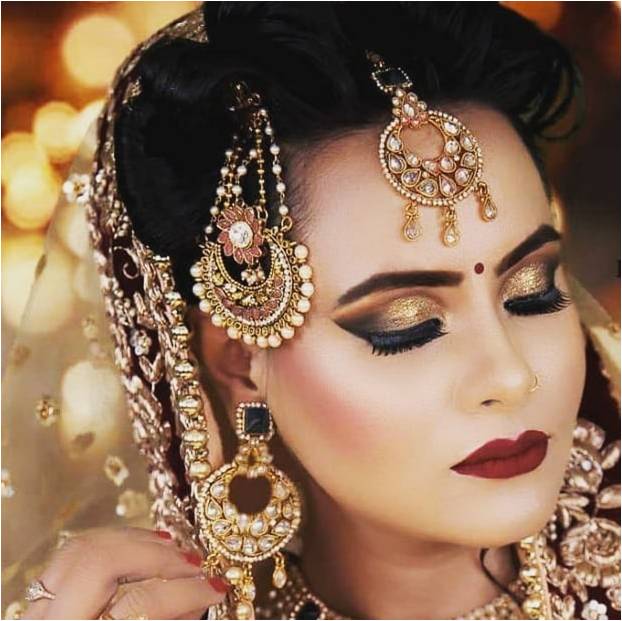 Woman with flawless HD makeup, wearing ornate jewelry and a decorative hairstyle, in a celebratory setting